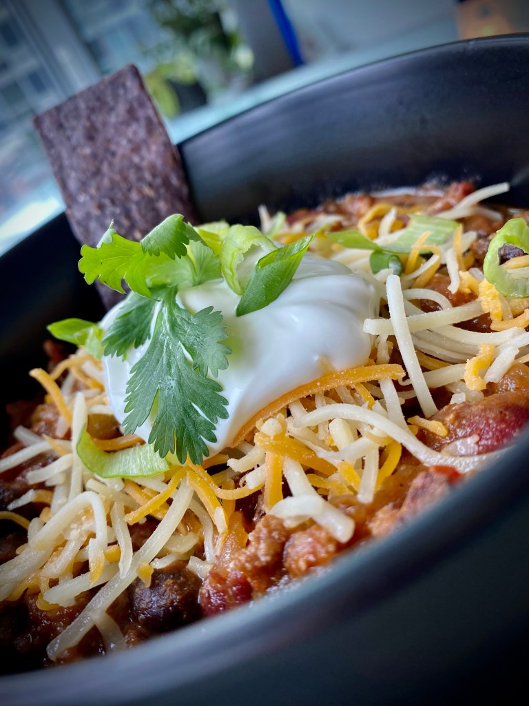 It's CHILI SEASON! And this is the, hands-down BEST bowl of chili ever -- because it includes BACON!! It's gluten free and the perfect comfort food! Bring on the fall! #food #recipe #chili #football #glutenfree #keto #paleo #healthyfood #bacon #cooking