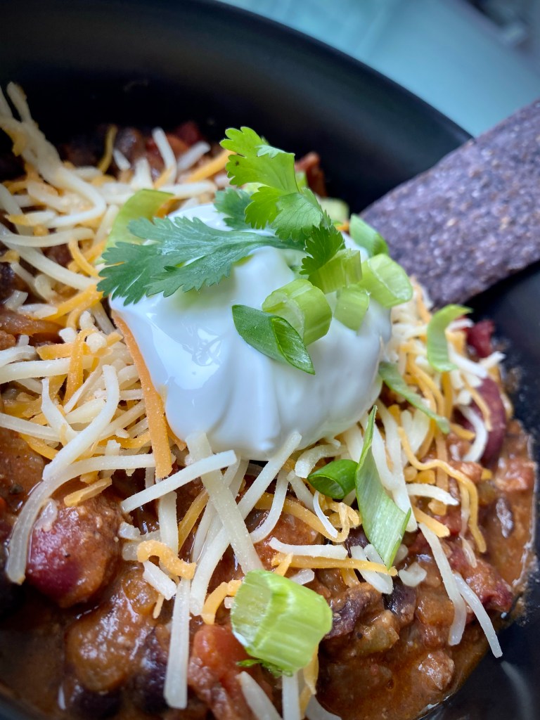 It's CHILI SEASON! And this is the, hands-down BEST bowl of chili ever -- because it includes BACON!! It's gluten free and the perfect comfort food! Bring on the fall! #food #recipe #chili #football #glutenfree #keto #paleo #healthyfood #bacon #cooking