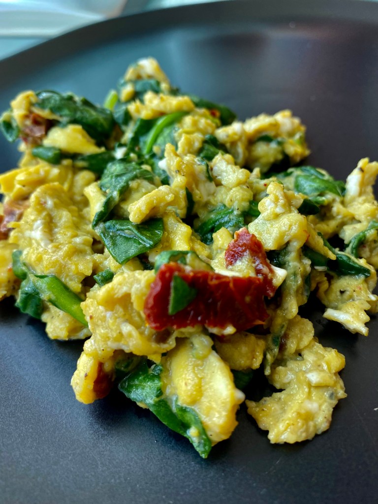 An easy and delicious breakfast recipe! Provençal Scrambled Eggs! Creamy and delicious and busying with flavor! Garlic, sun dried tomatoes and spinach come together for this brunch classic! #food #breakfast #healthyfood #eggs #glutenfree #paleo #keto #scd #cooking #brunch
