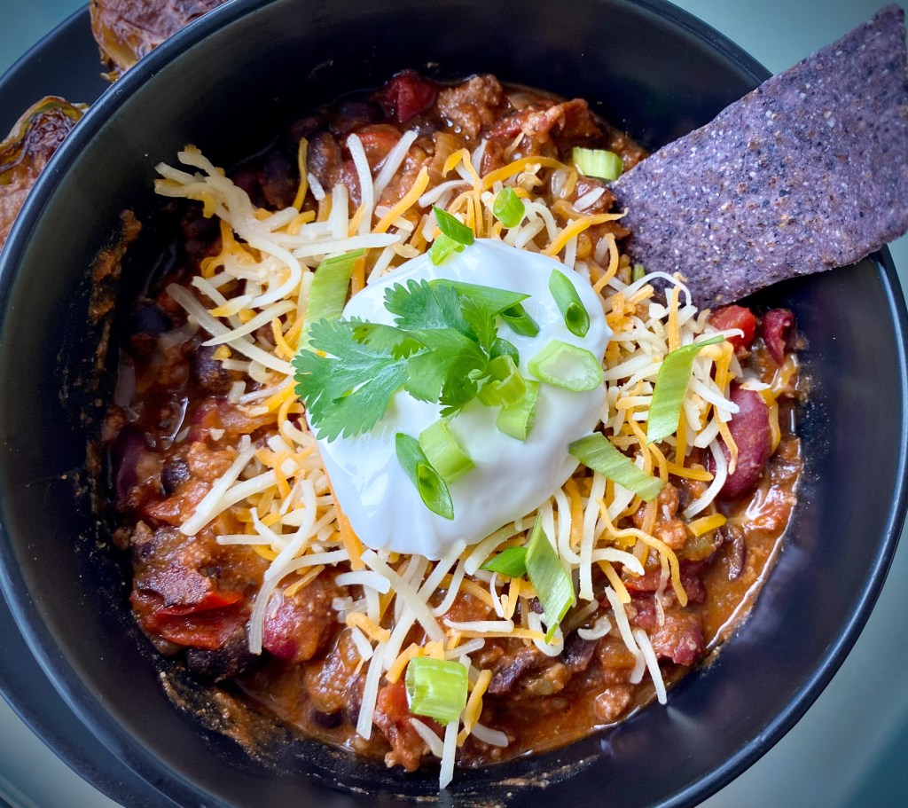 It's CHILI SEASON! And this is the, hands-down BEST bowl of chili ever -- because it includes BACON!! It's gluten free and the perfect comfort food! Bring on the fall! #food #recipe #chili #football #glutenfree #keto #paleo #healthyfood #bacon #cooking